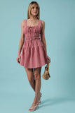 Woman wearing a pink checkered dress against a light blue background
