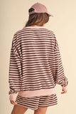 Person wearing a striped outfit with a cap on a beige background