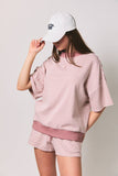 Person wearing a pink and white striped outfit with a matching cap on a plain background