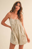 Woman wearing a plaid romper on a beige background