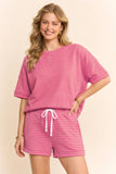 Woman wearing a pink striped outfit on a beige background