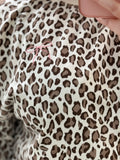 Leopard print fabric with a pink thread visible in the shape of a bow