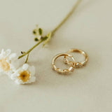 Gold ring with textured design on a light background with flowers