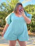 Person wearing a light blue outfit taking a mirror selfie outdoors.