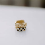 Two gold rings with different designs on a light gray background