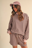 Person wearing a striped outfit with a cap on a beige background