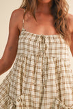 Woman wearing a plaid dress with a neutral background