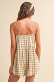 Woman wearing a plaid dress with thin straps on a beige background