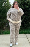 Person wearing a leopard print outfit with a white background showing that the pants have pockets