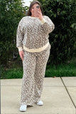 Person wearing a leopard print outfit and white sneakers, standing outdoors.