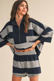 Woman wearing a navy and gray striped outfit on a beige background